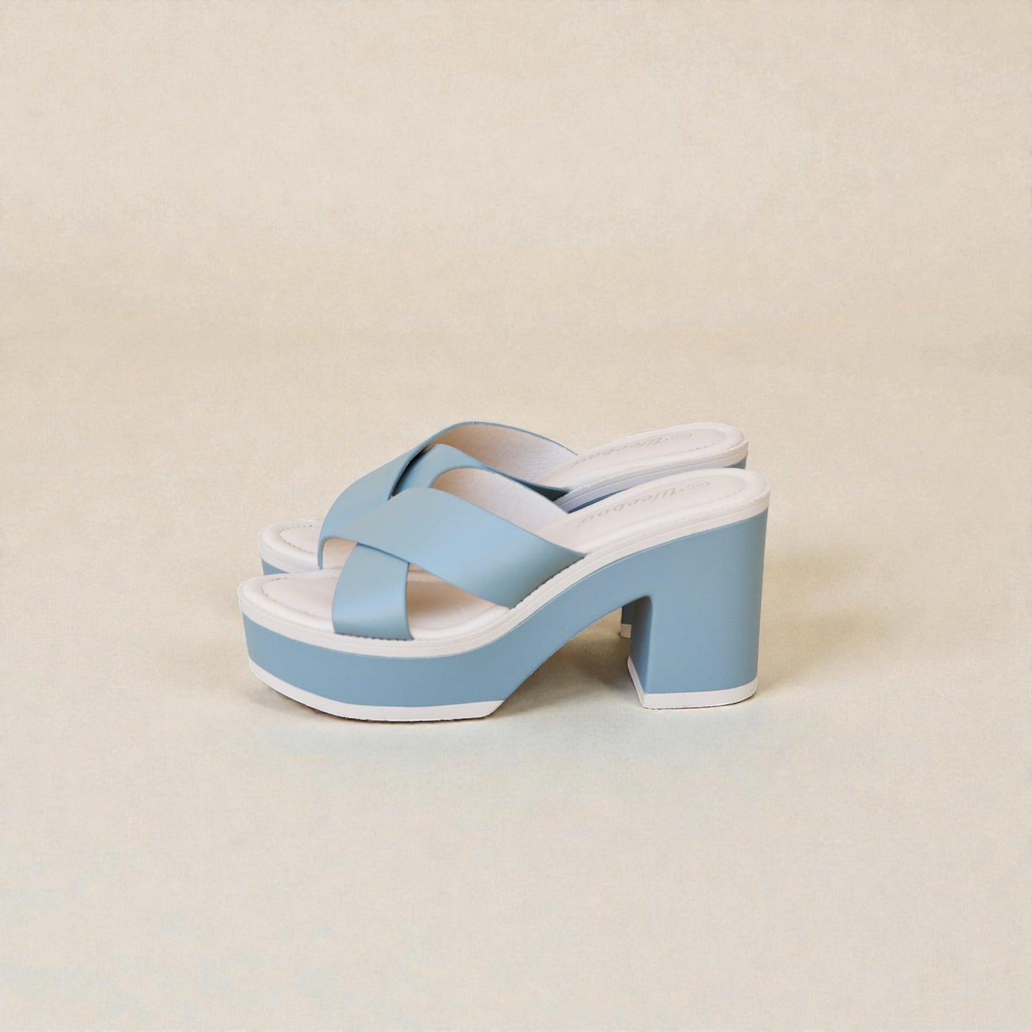 Blue sandal with a white sole on a beige background
