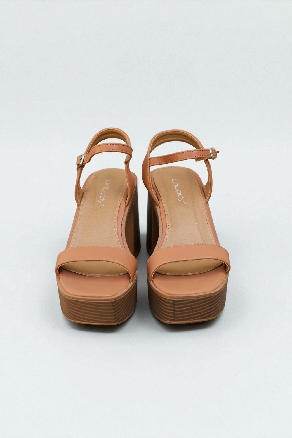 Pair of tan platform sandals on a white background