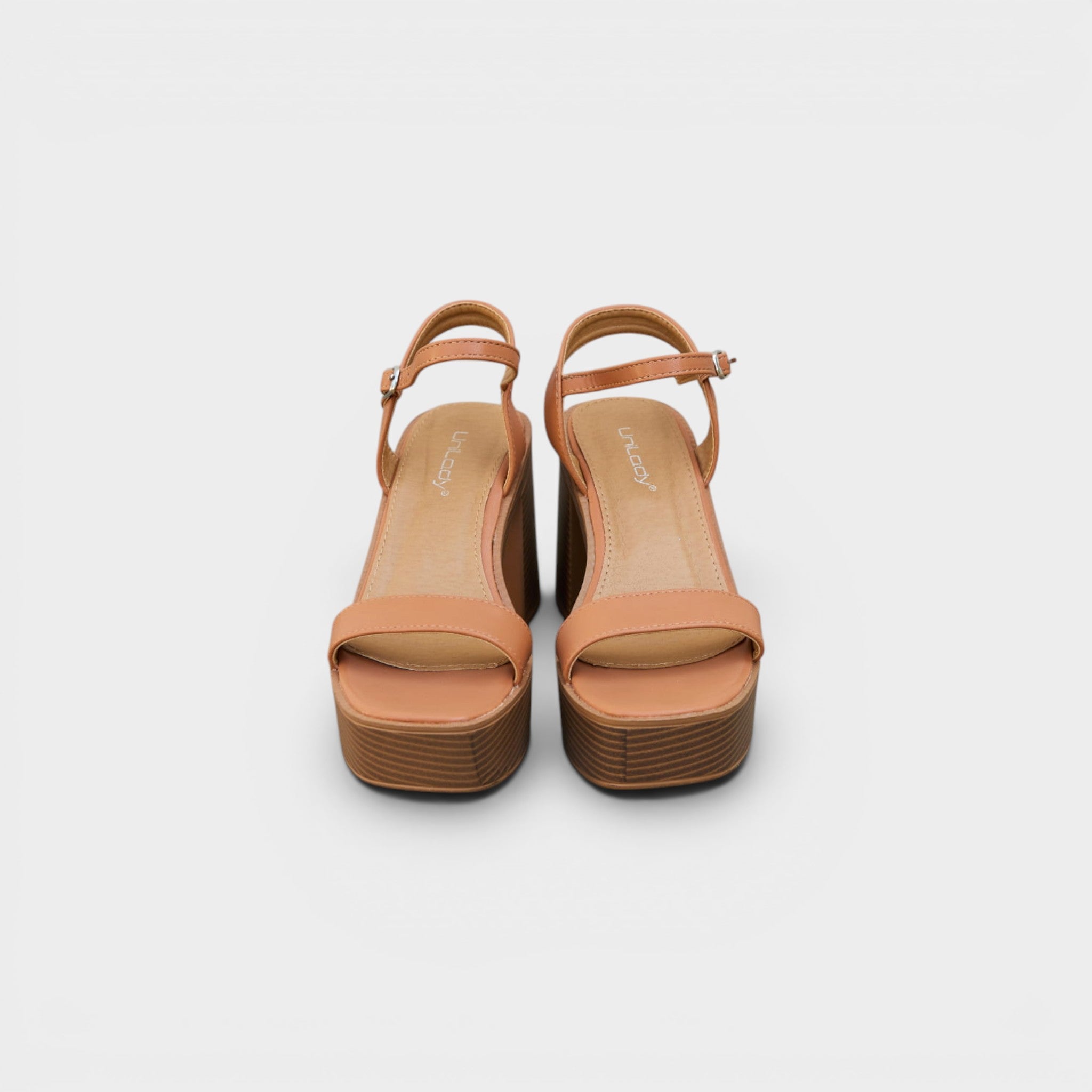 Pair of tan high-heeled sandals on a white background