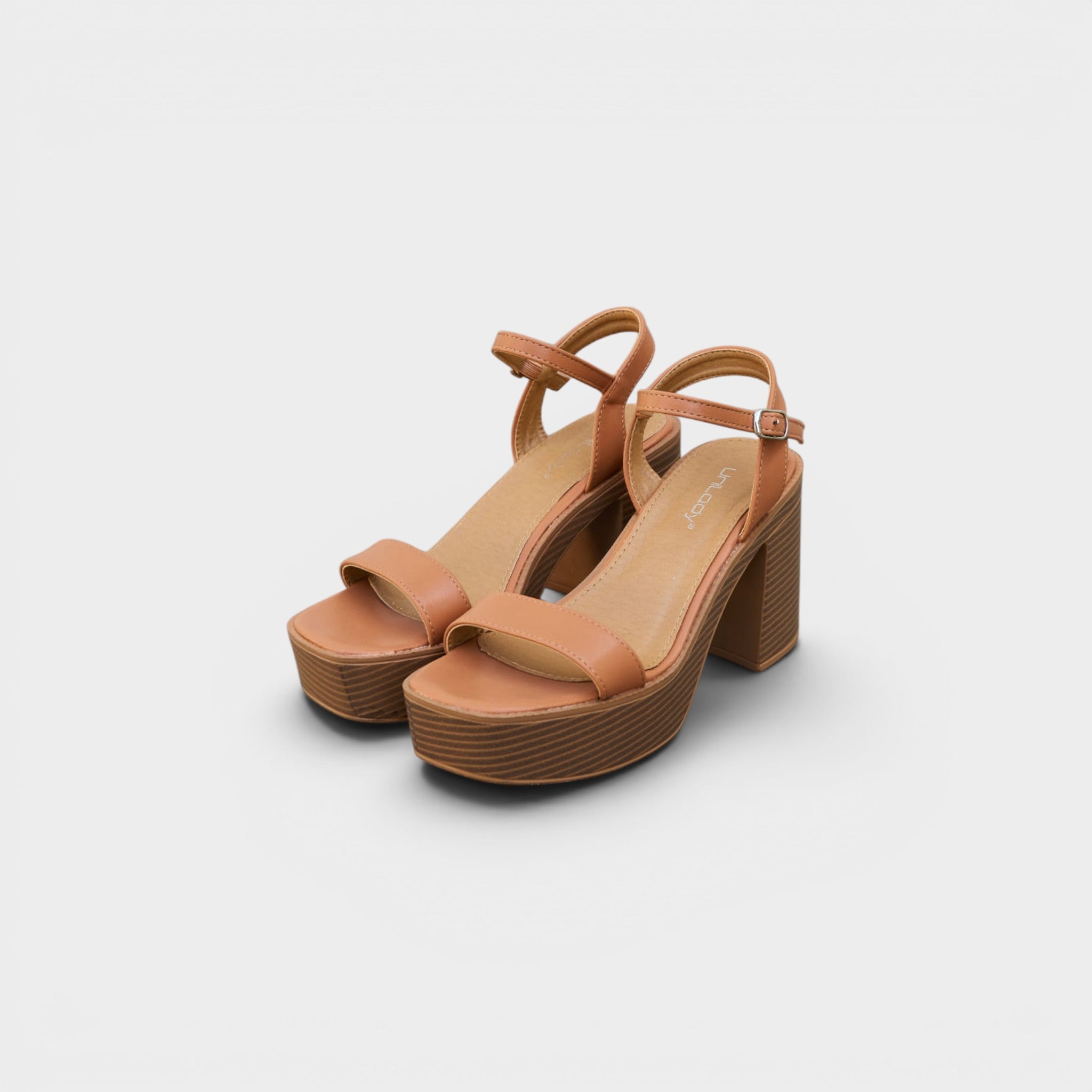Pair of tan platform sandals on a white background