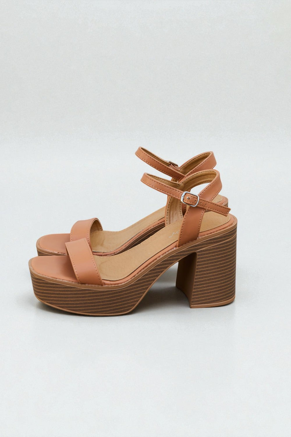 Tan platform sandal with block heel on a white background