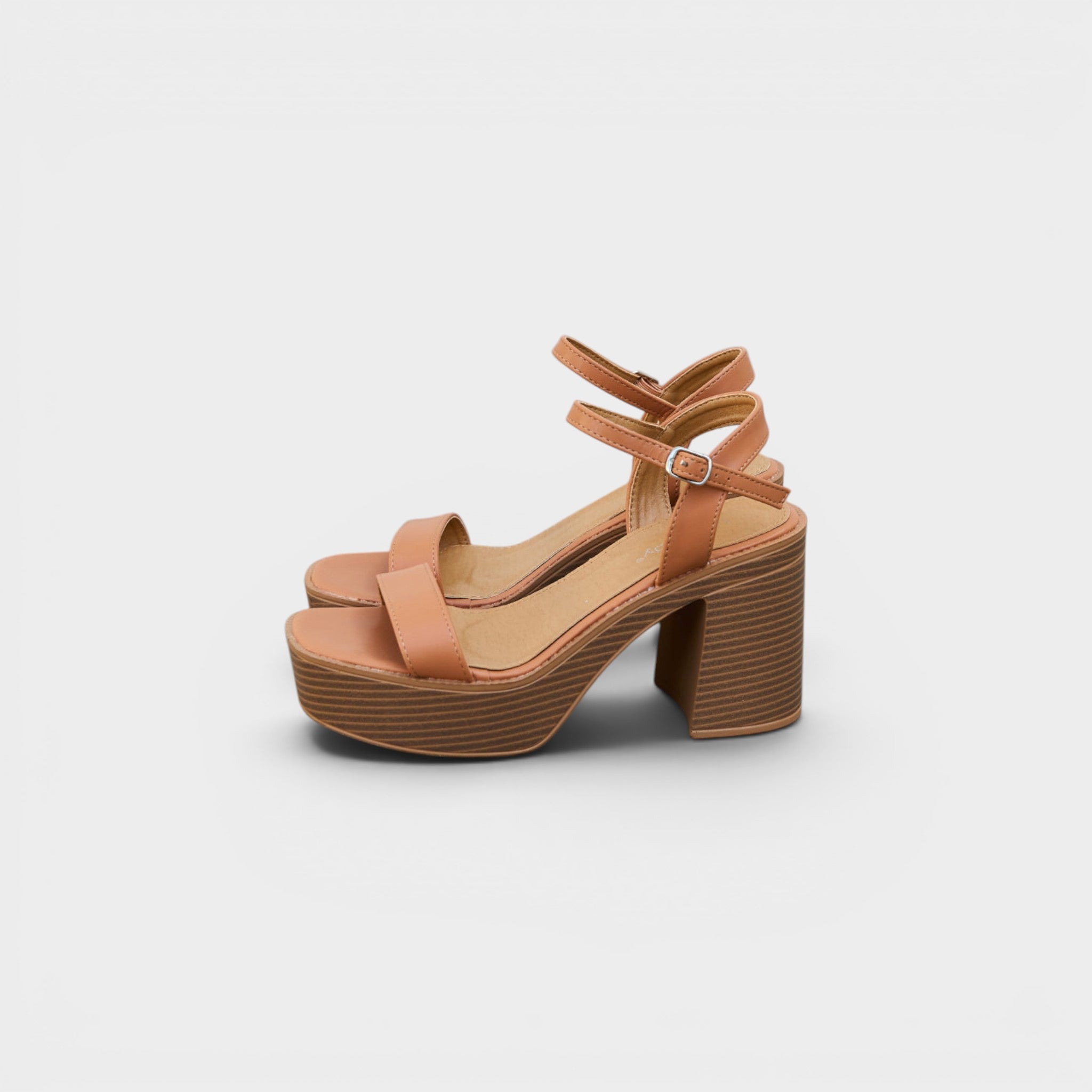 Tan high-heeled sandals on a light gray background