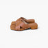 A pair of women's clog sandals in tan leather and light brown wood, featuring a low block heel and silver-tone rivets, shown on a plain white background.