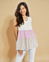 Woman wearing a layered sleeveless top with pink and beige sections on a beige background