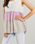 Woman wearing a layered top with white, pink, and beige sections on a plain background