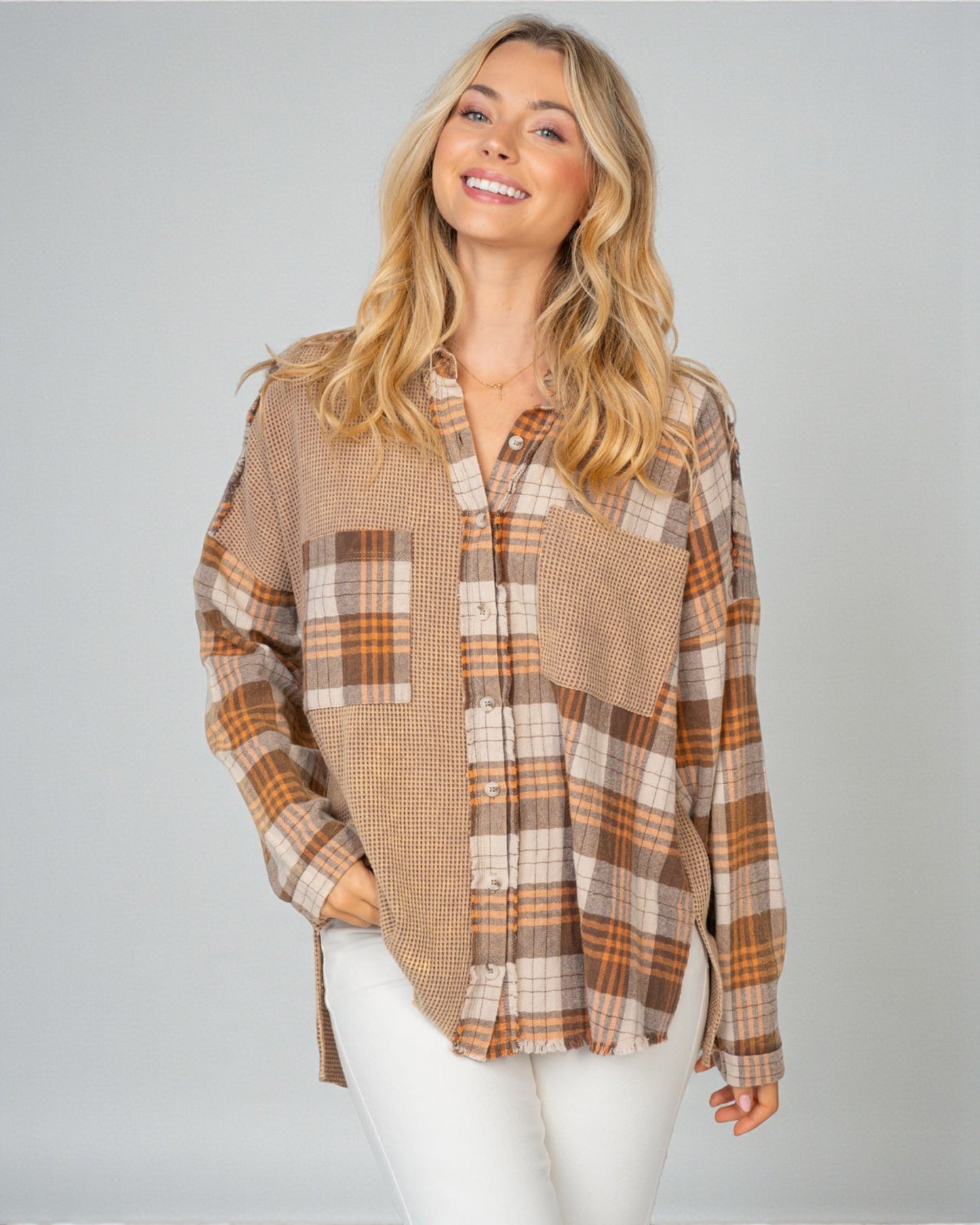 Woman wearing a plaid shirt with a neutral color palette on a gray background