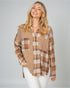 Woman wearing a plaid shirt with a neutral color palette on a gray background