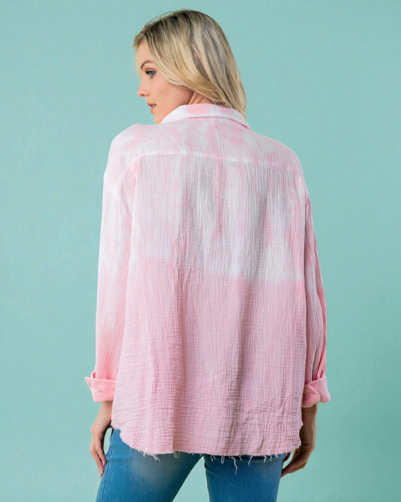 Woman wearing a pink and white tie-dye shirt against a teal background