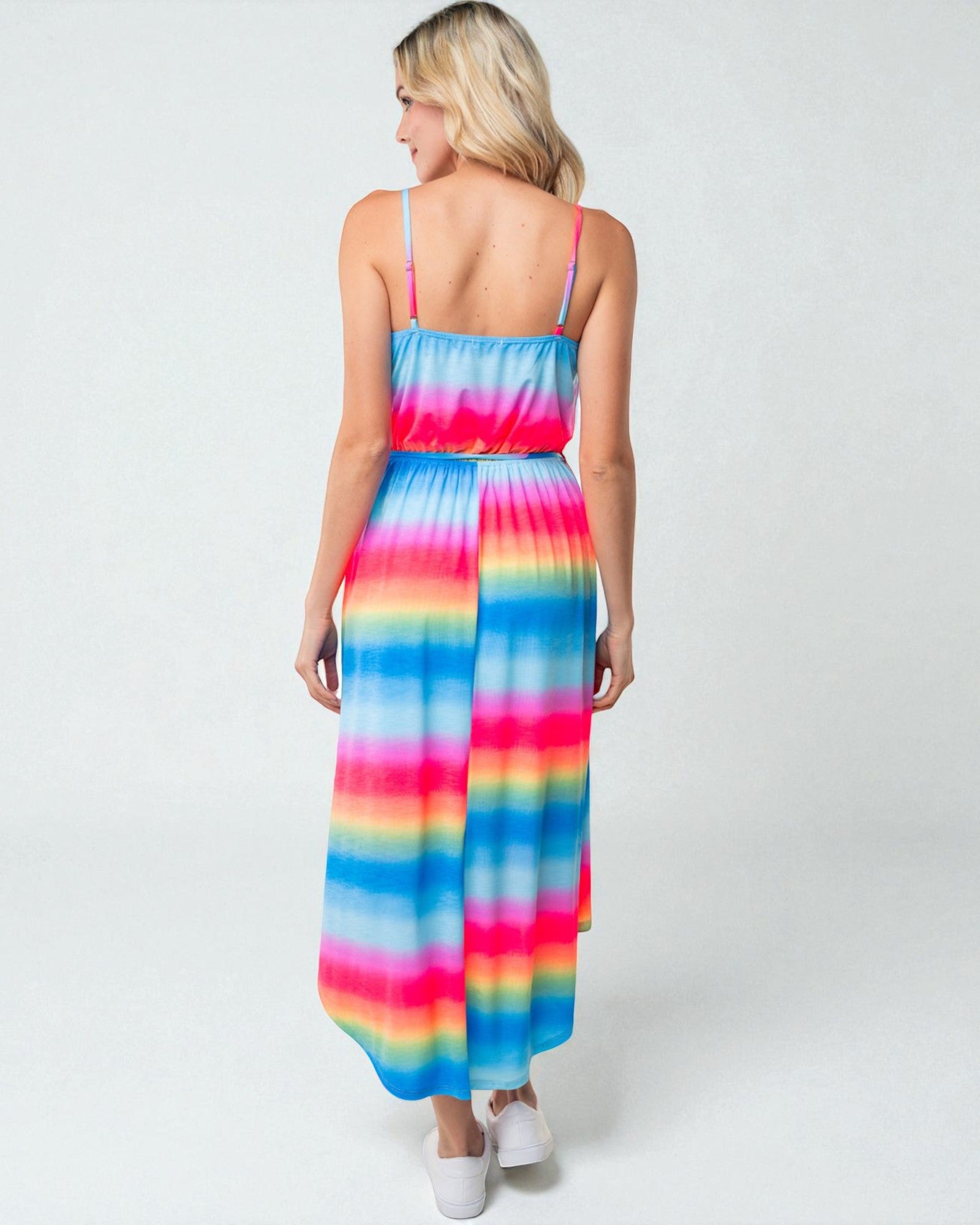 Woman wearing a colorful tie-dye dress on a white background