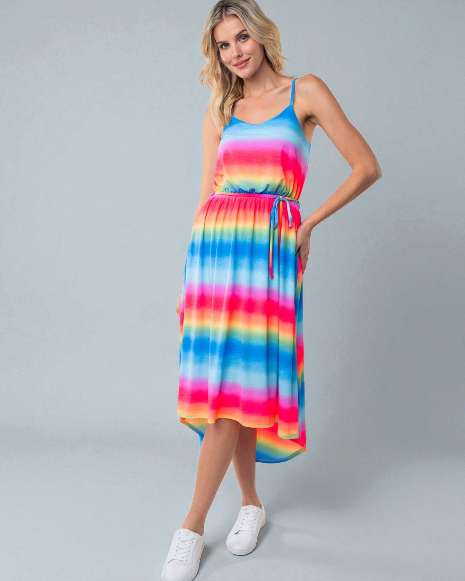 Woman wearing a colorful striped dress on a gray background