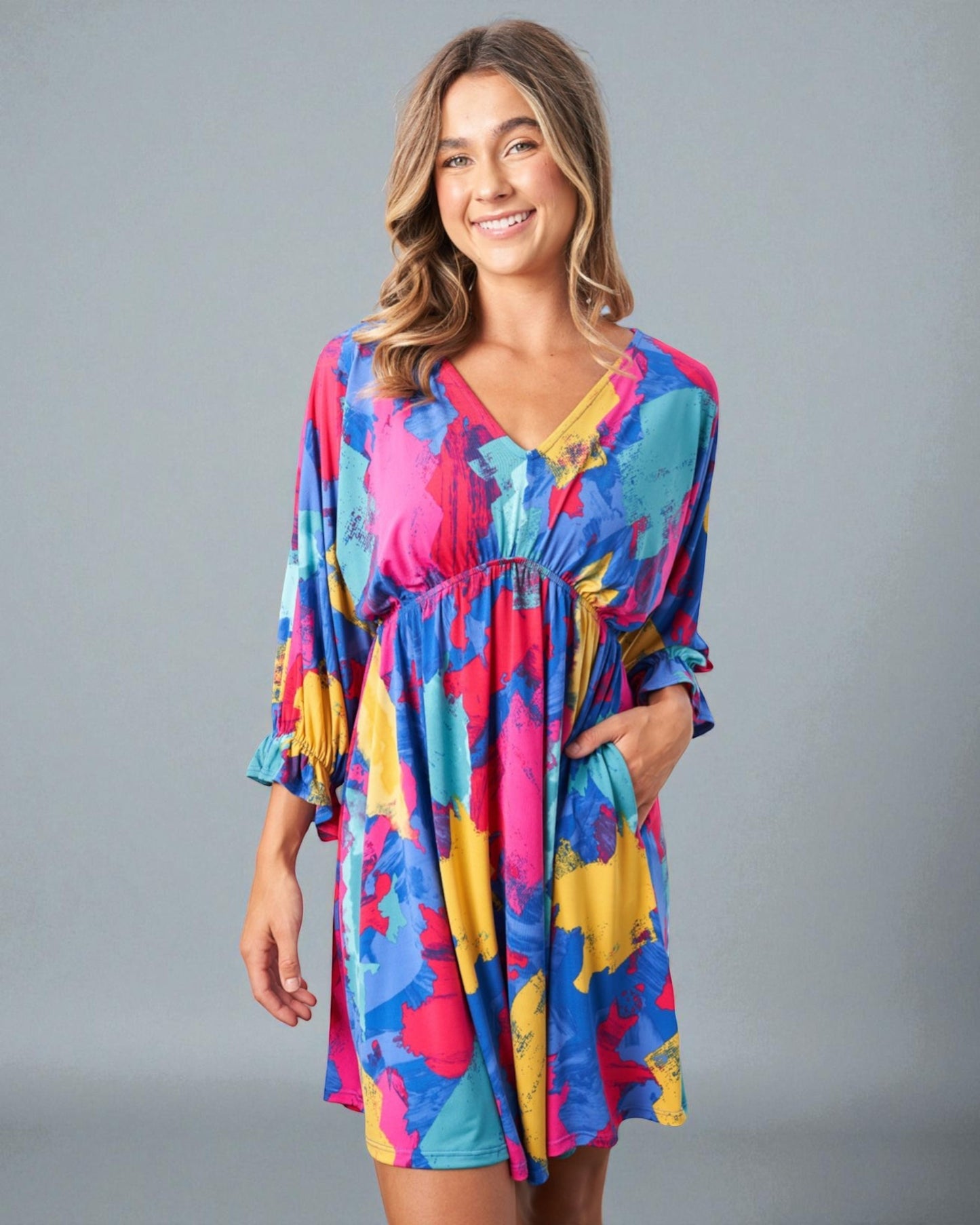 Woman wearing a colorful dress against a gray background