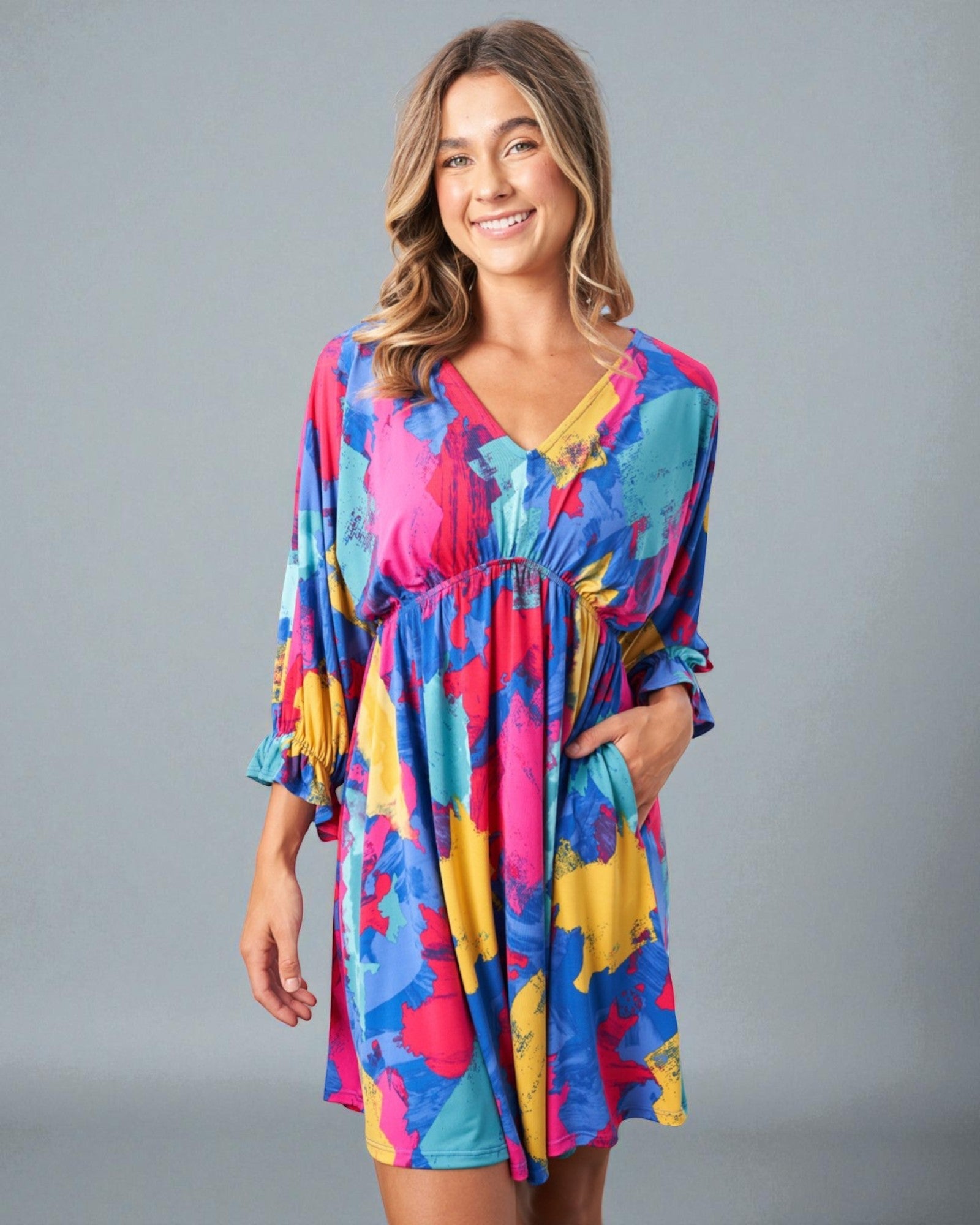 Woman wearing a colorful dress against a gray background