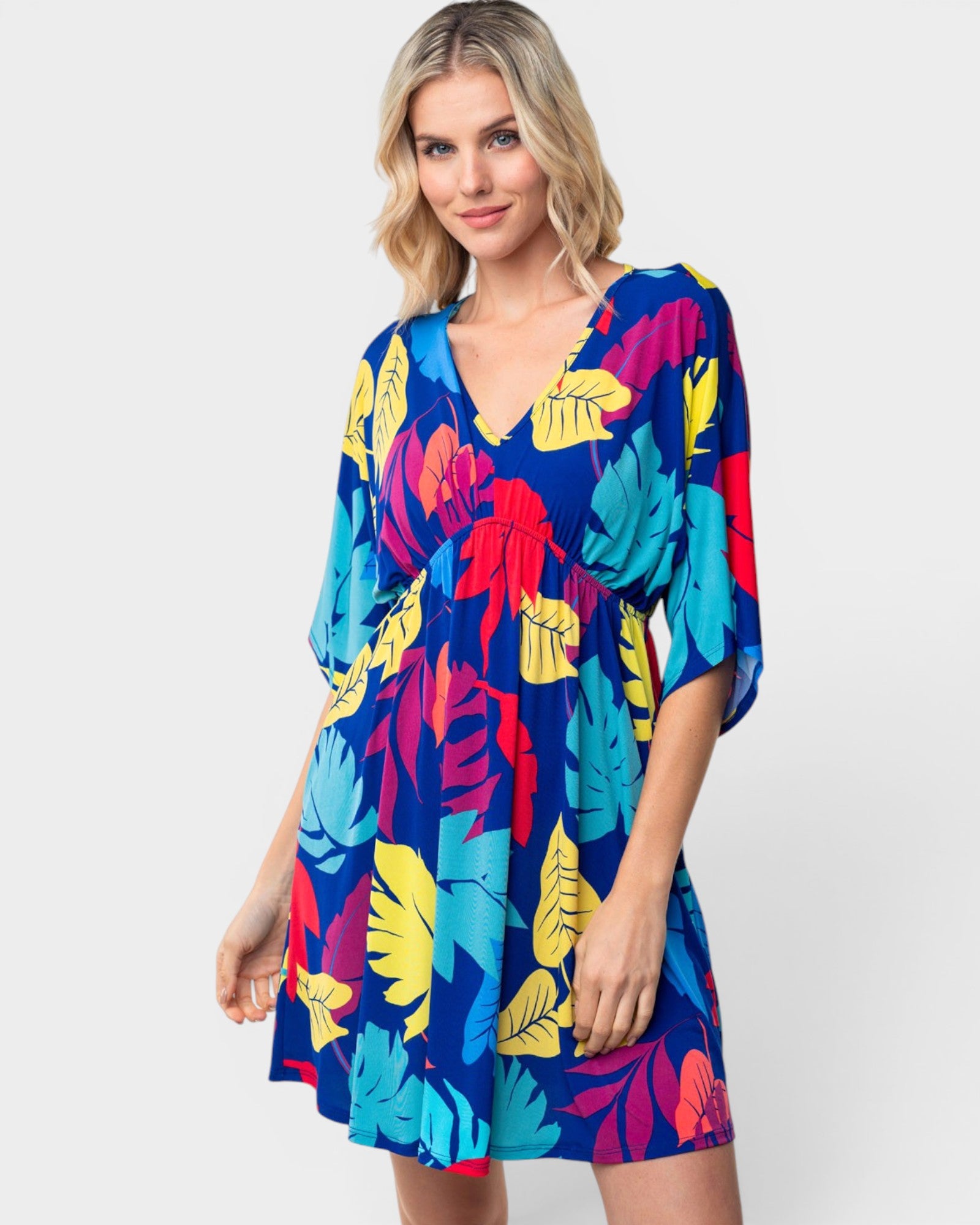 Woman wearing a colorful tropical pattern dress on a white background