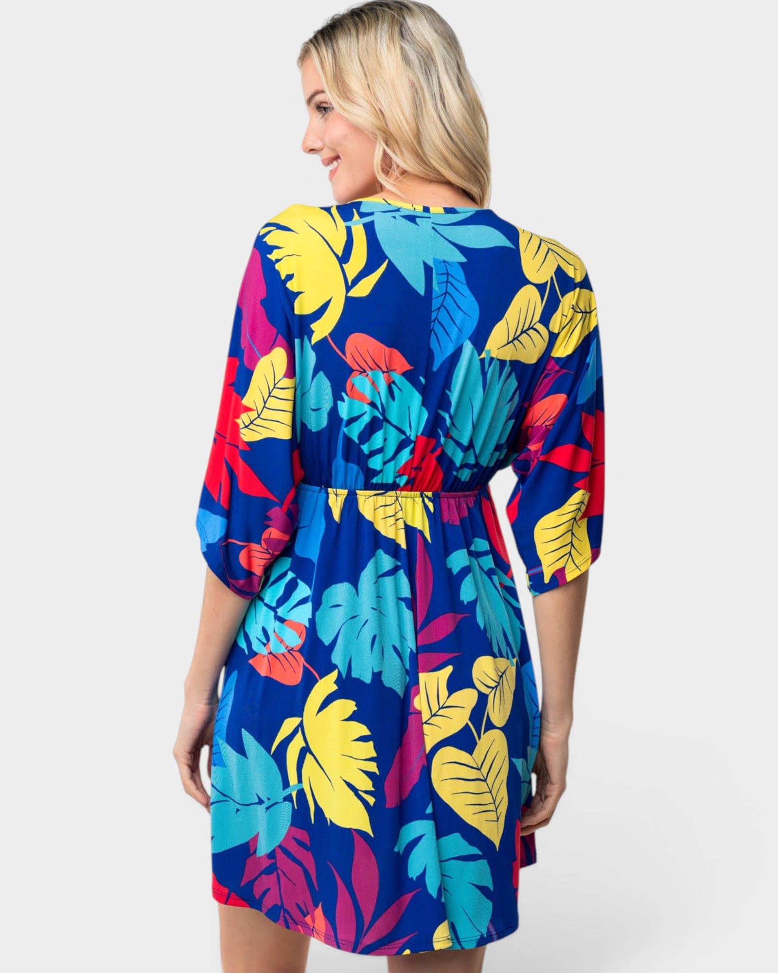 Woman wearing a colorful tropical pattern dress on a white background