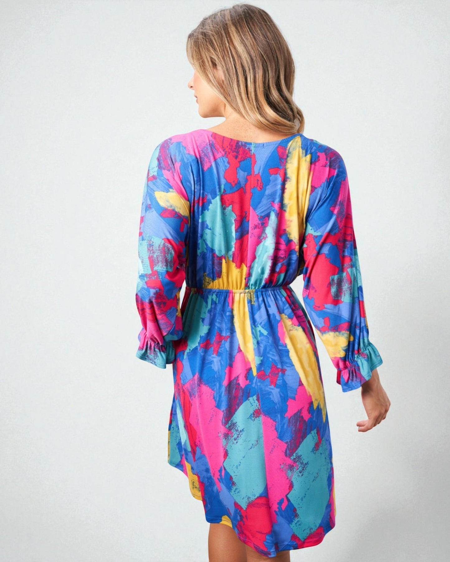 Woman wearing a colorful dress with abstract pattern on a white background