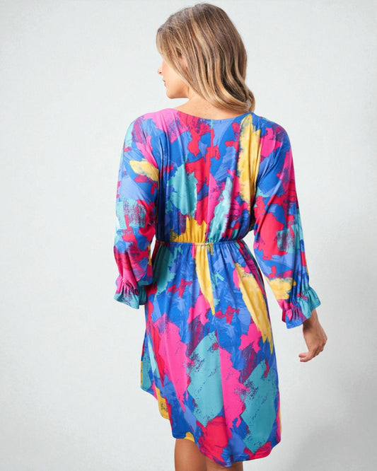 Woman wearing a colorful dress with abstract pattern on a white background