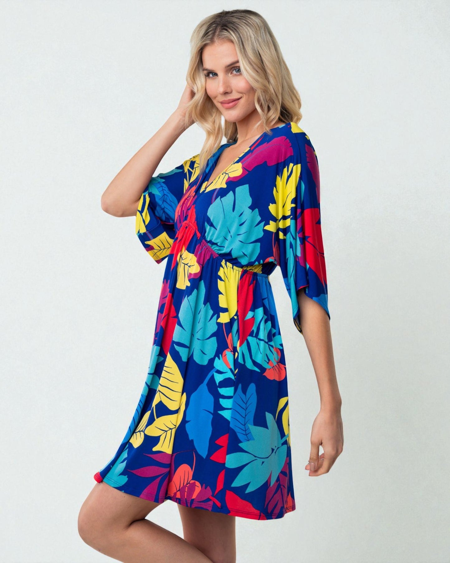 Woman wearing a colorful tropical leaf pattern dress on a white background