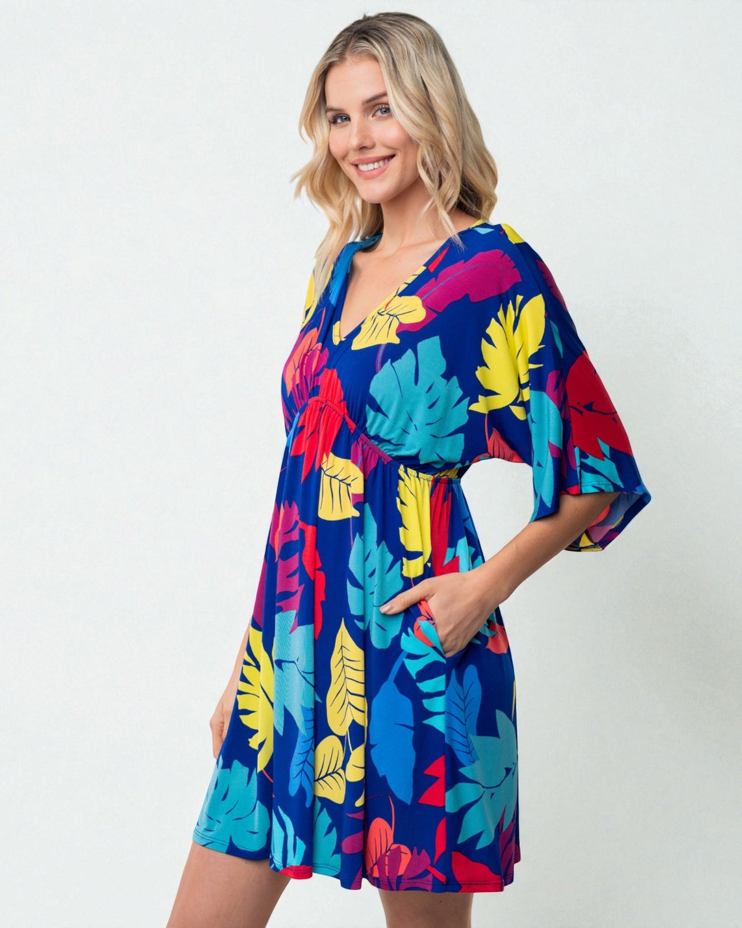 Woman wearing a colorful tropical print dress on a white background