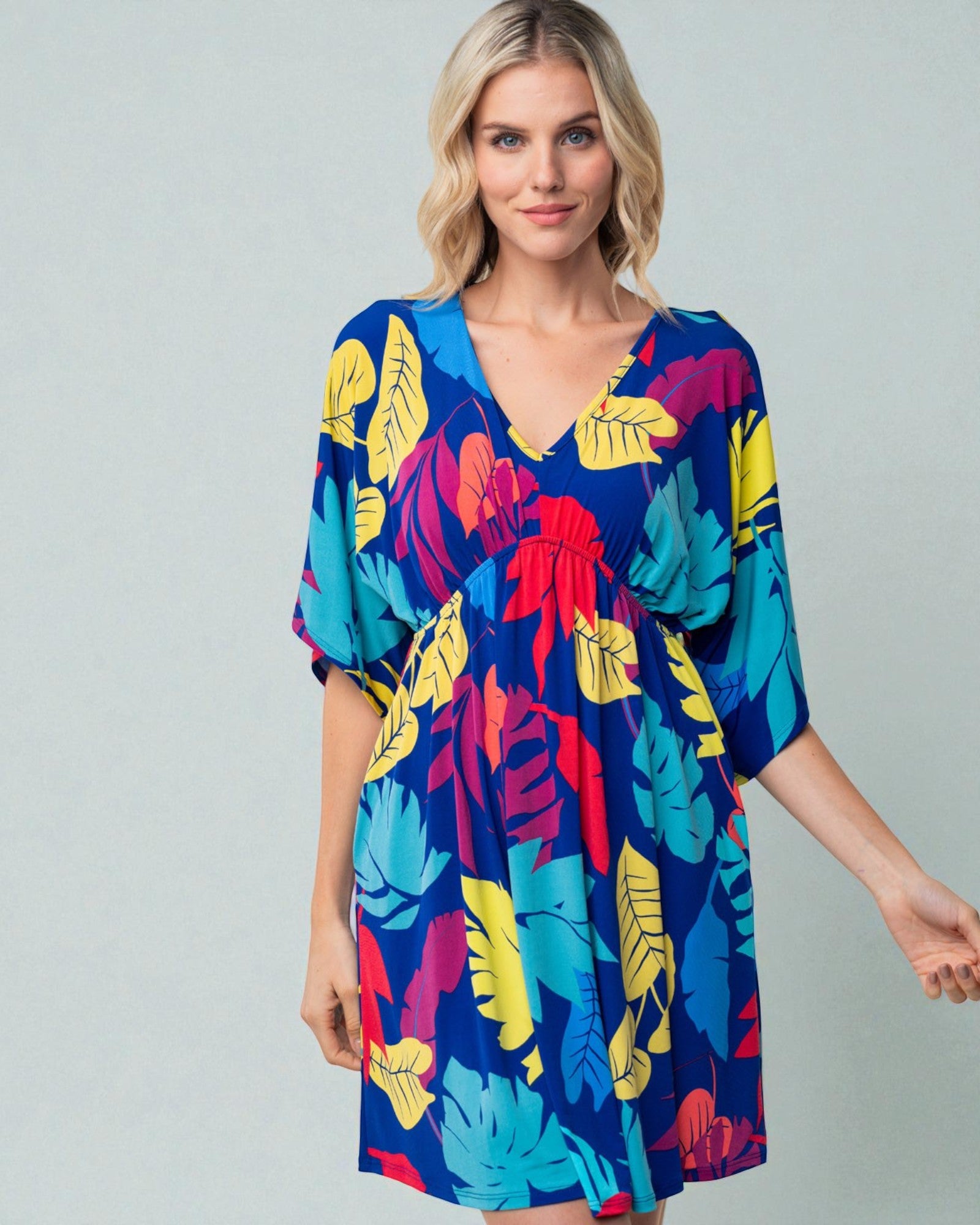 Woman wearing a colorful floral dress on a gray background