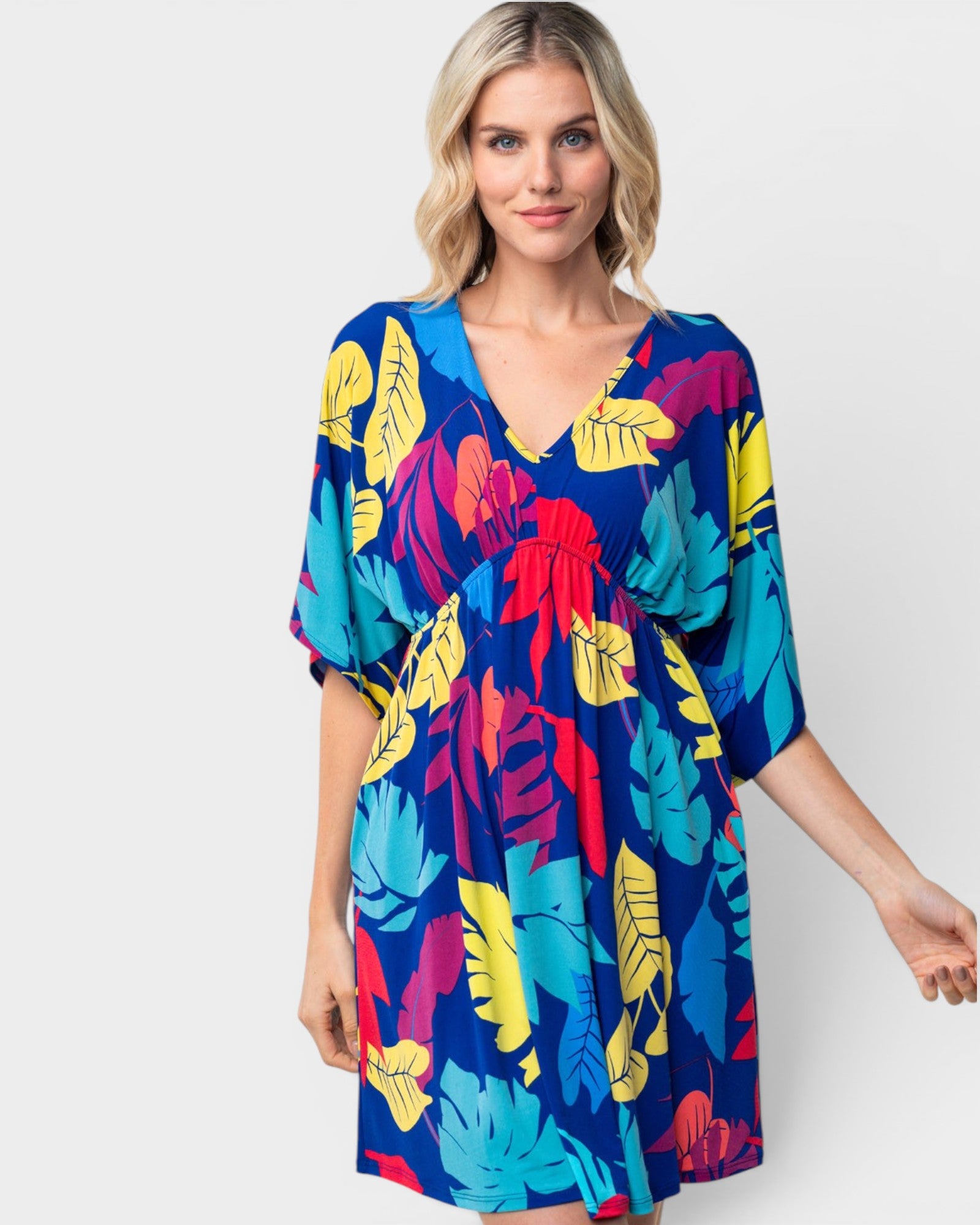 Woman wearing a colorful tropical print dress on a white background