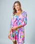 Woman wearing a colorful dress with a floral pattern on a gray background