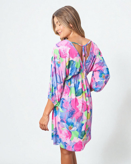 Woman wearing a colorful floral dress on a white background