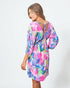 Woman wearing a colorful floral dress on a white background
