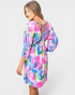 Woman wearing a colorful floral dress on a white background