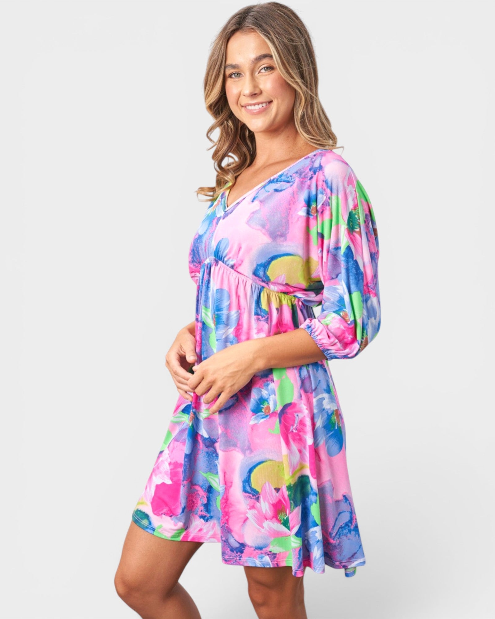 Woman wearing a colorful floral dress on a white background