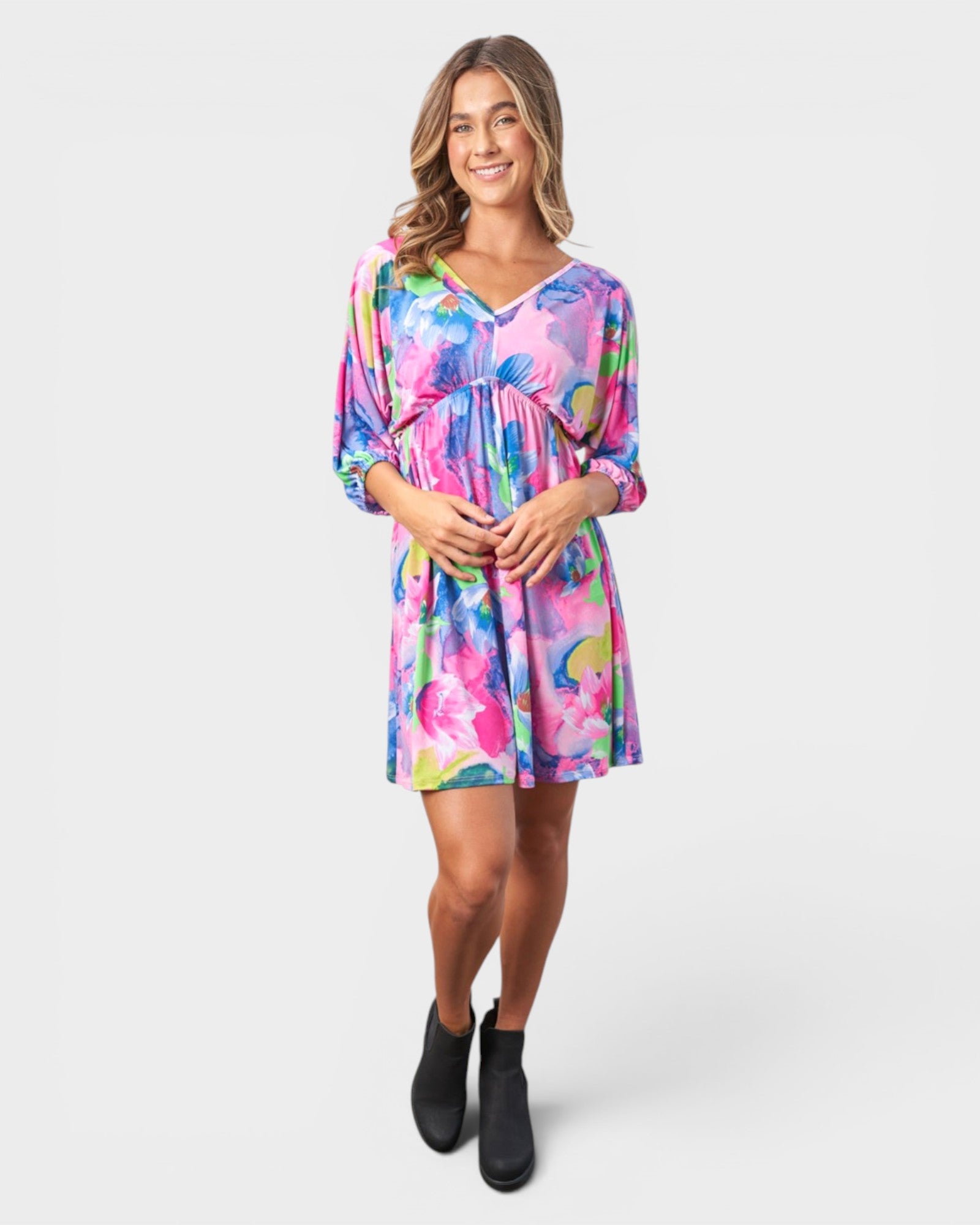 Woman wearing a colorful floral dress on a white background