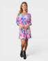 Woman wearing a colorful floral dress on a white background