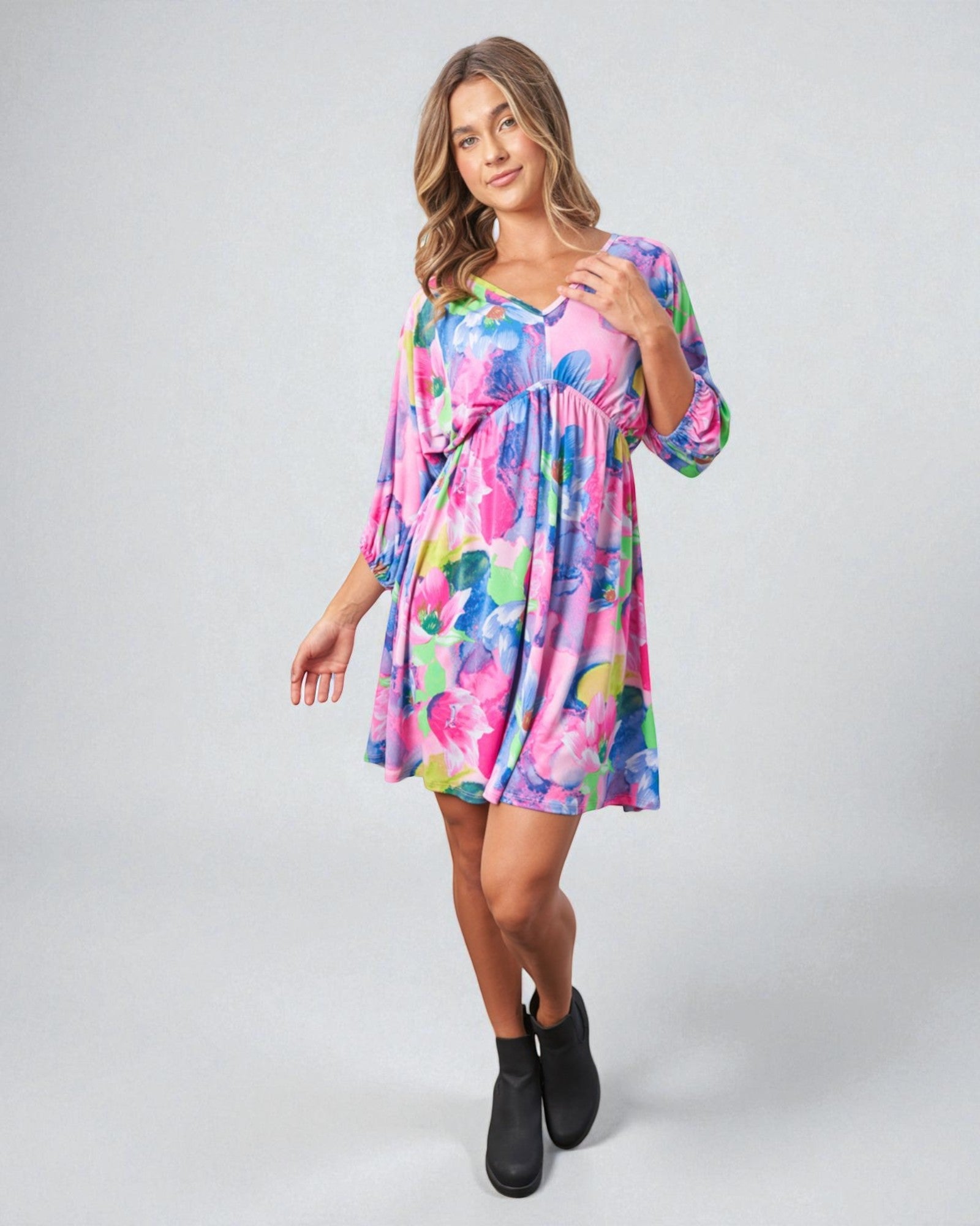 Woman wearing a colorful floral dress on a white background