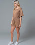 Woman wearing a brown romper on a gray background