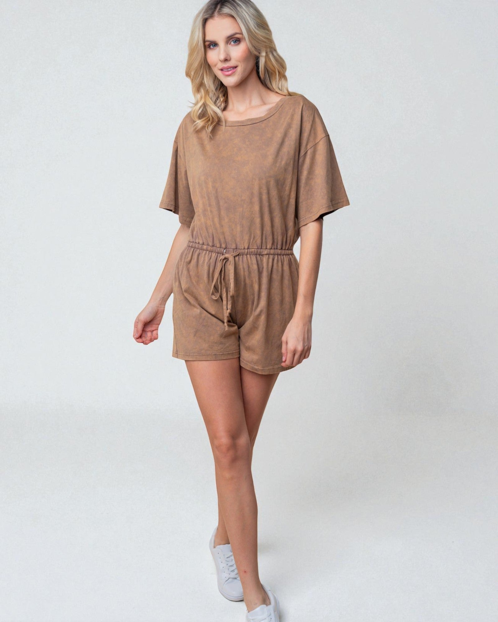 Woman wearing a brown romper on a white background