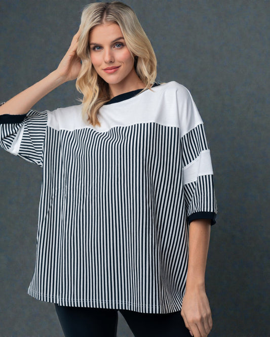 Woman wearing a black and white striped shirt against a gray background