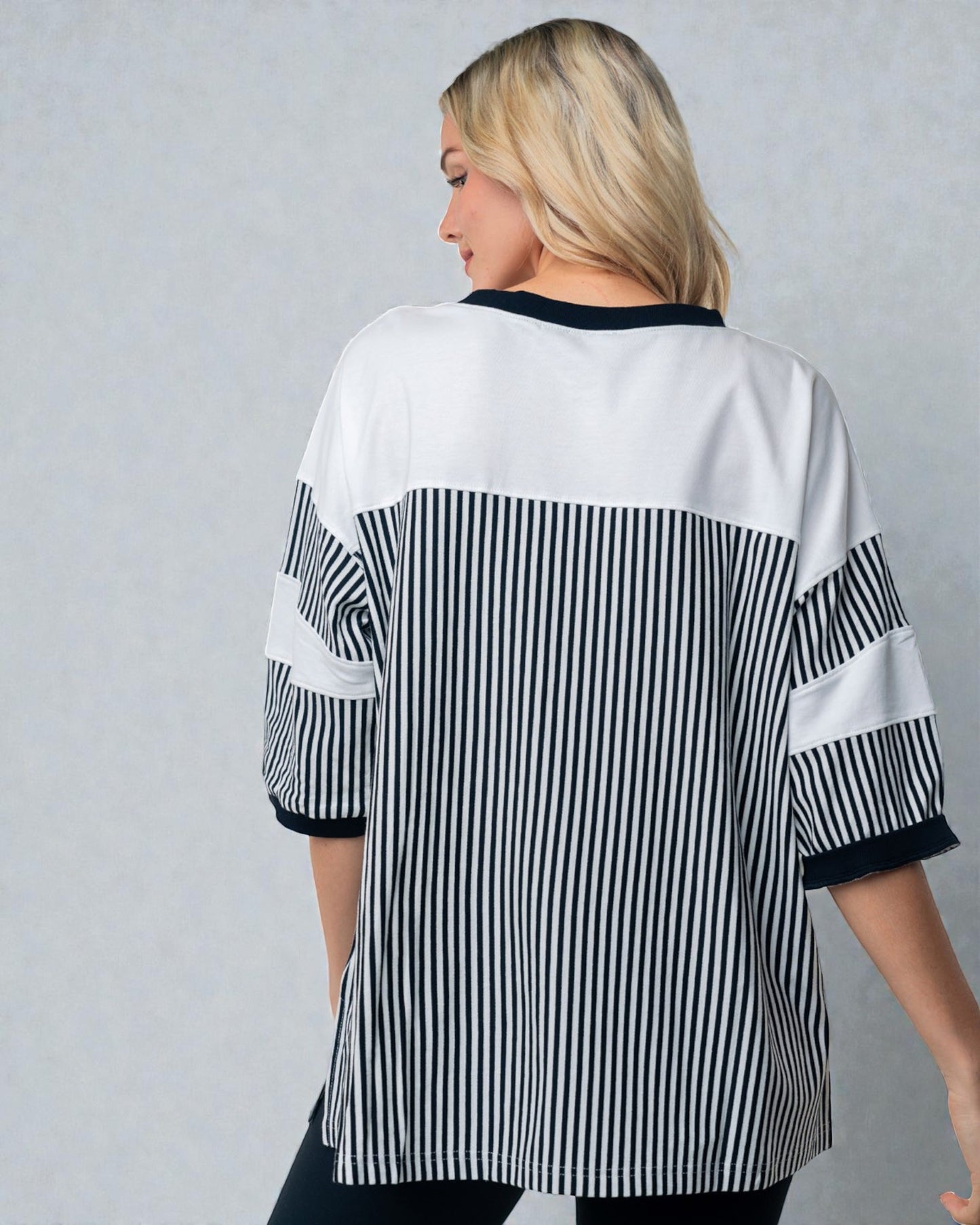 Person wearing a black and white striped shirt against a gray background