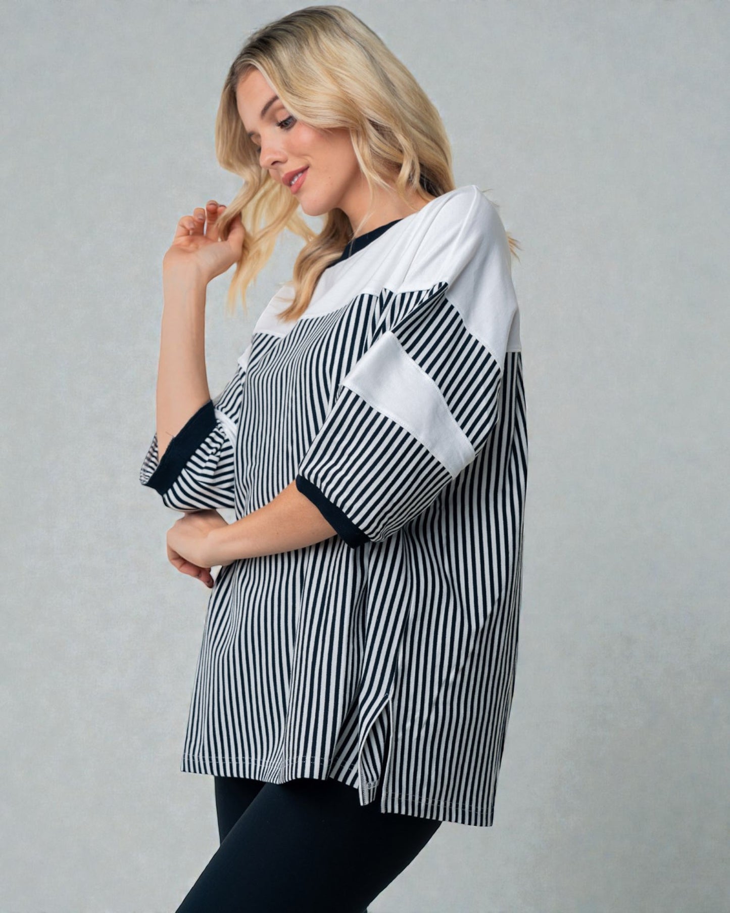 Woman wearing a black and white striped shirt against a gray background