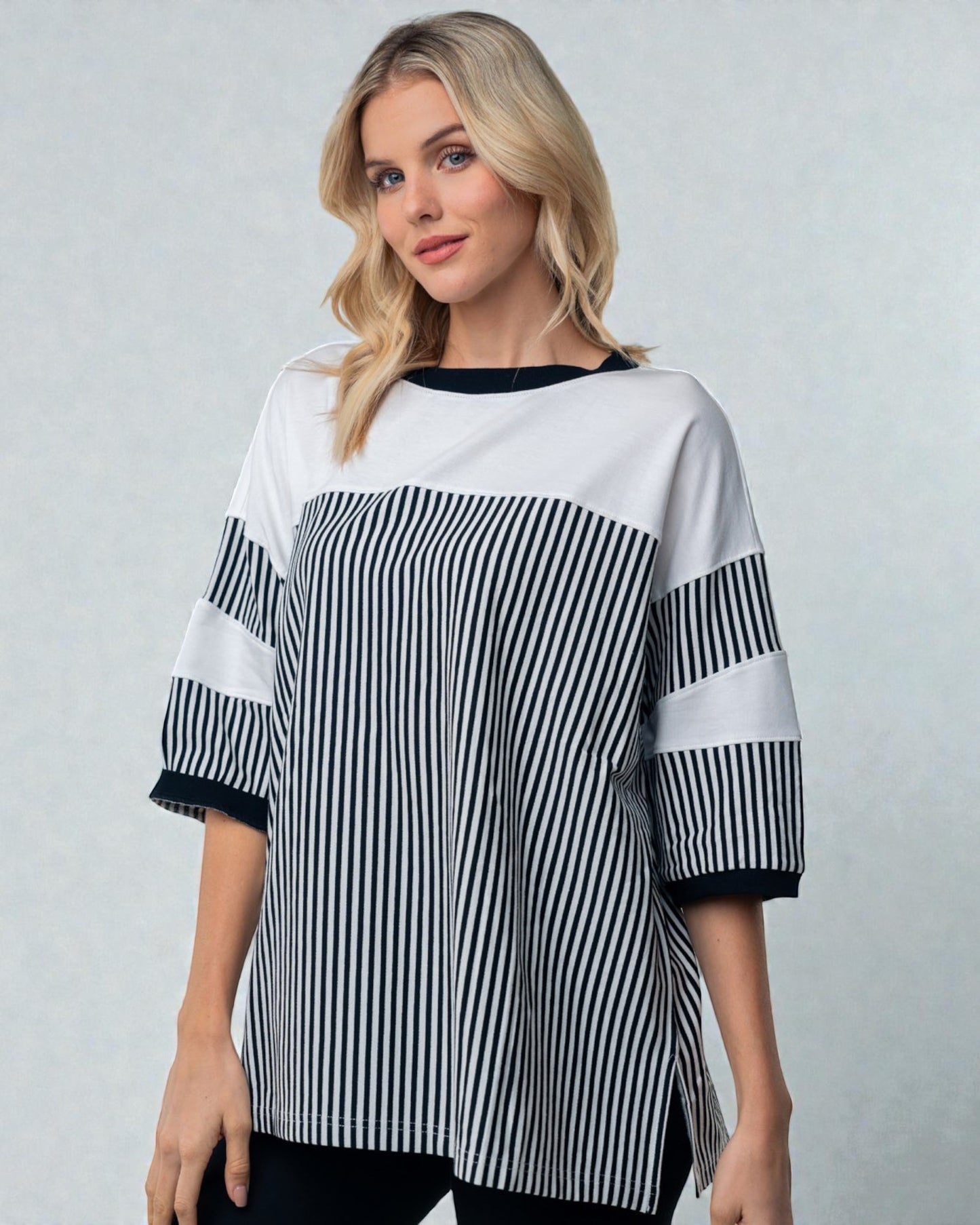 Woman wearing a black and white striped shirt against a gray background