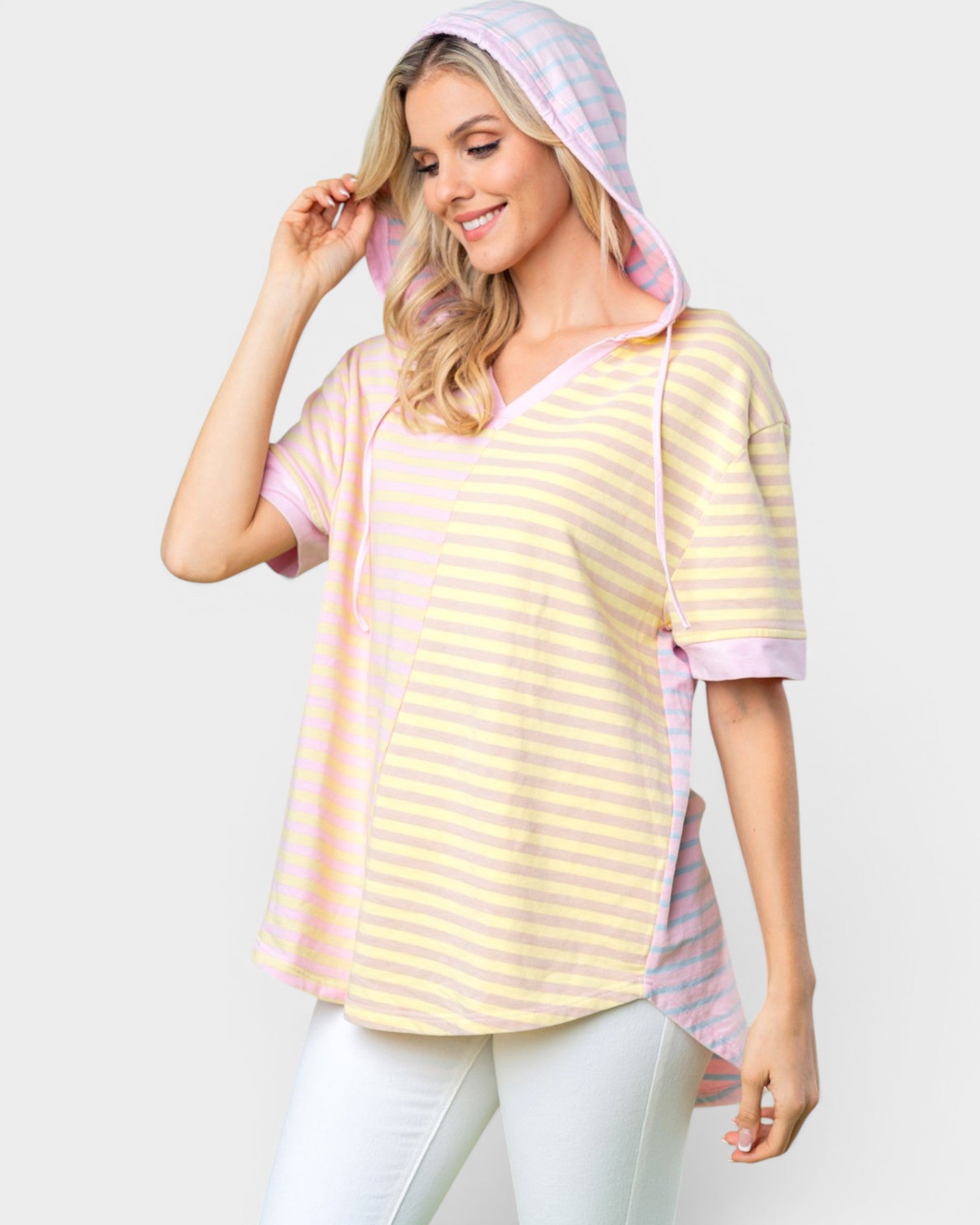Woman wearing a yellow and pink striped hoodie with a hood on a white background