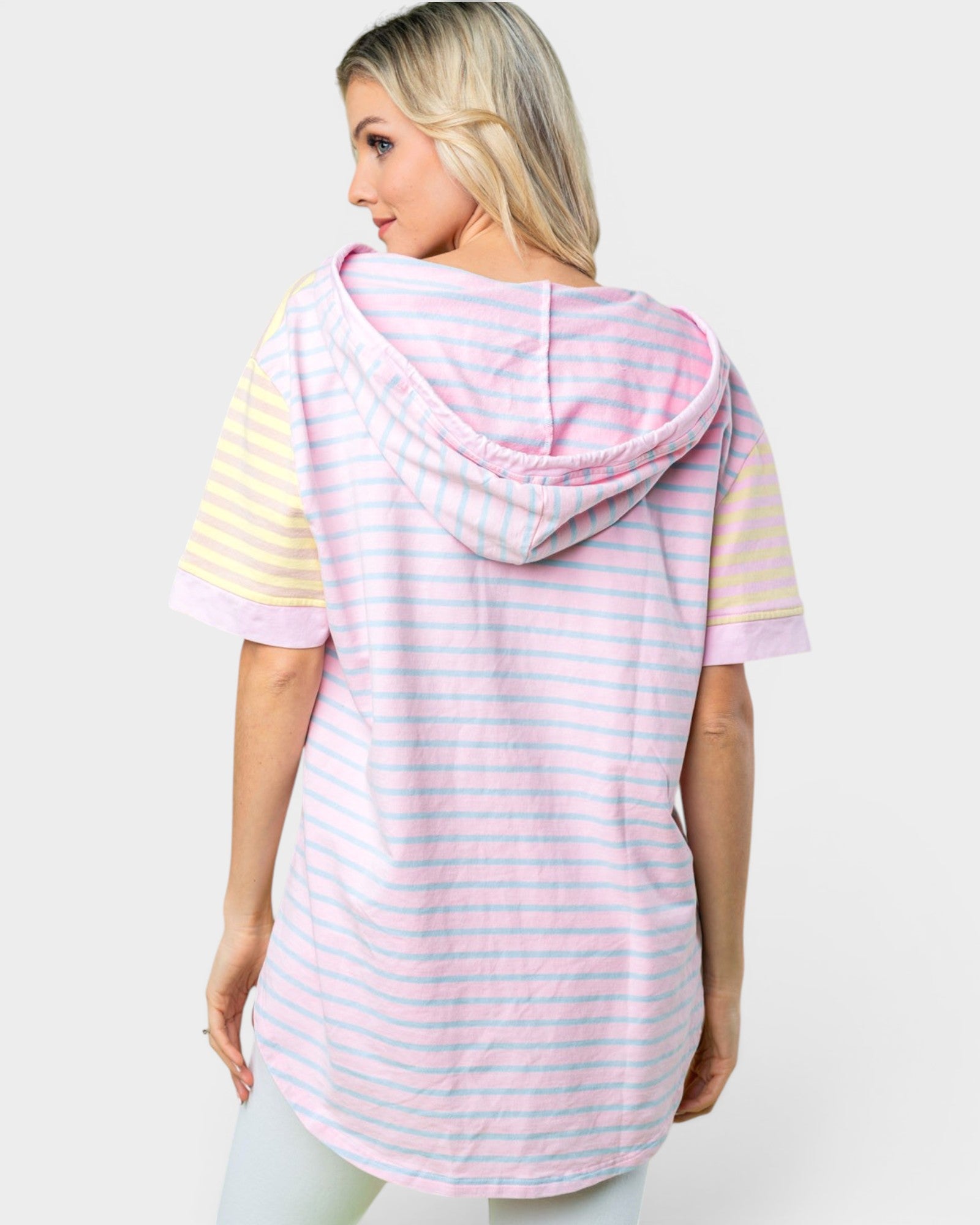 Woman wearing a pastel striped hoodie with a hood on a white background