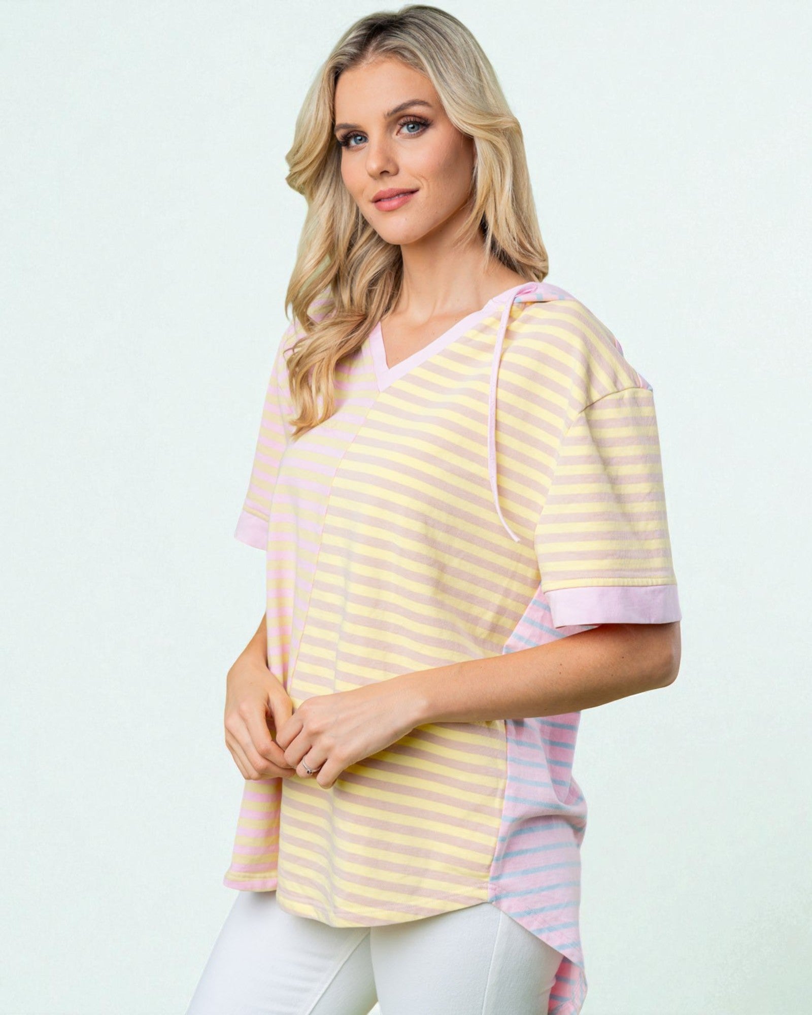 Woman wearing a yellow and pink striped shirt on a white background