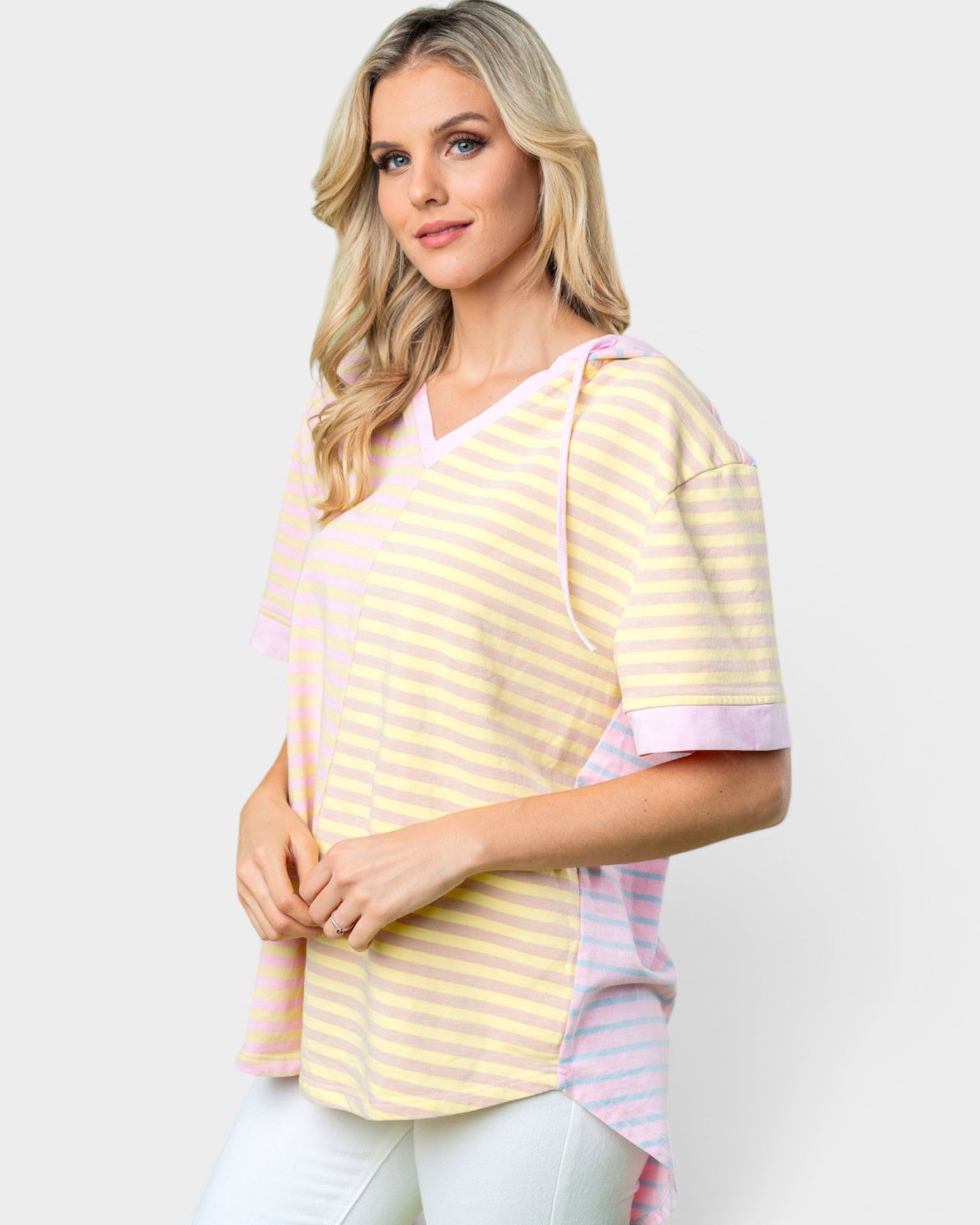 Woman wearing a yellow and pink striped shirt against a white background