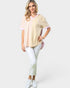 Woman wearing a yellow striped shirt and white pants on a white background