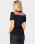 Woman wearing a black top with sheer sleeves and mesh back on a white background