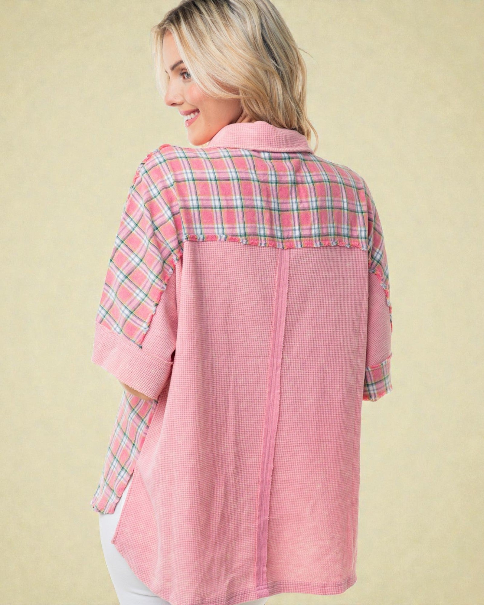 Woman wearing a pink plaid shirt against a beige background