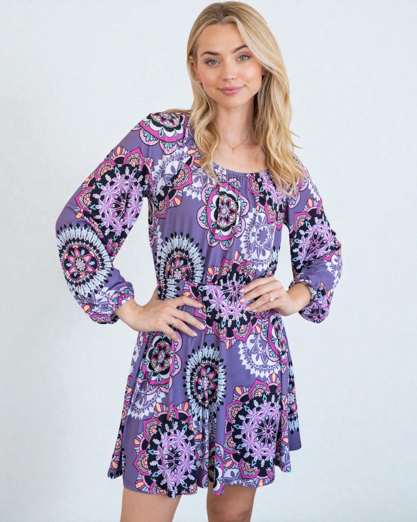 Woman wearing a purple patterned dress on a white background
