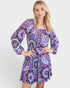 Woman wearing a purple patterned dress on a white background