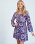 Woman wearing a purple patterned dress on a white background