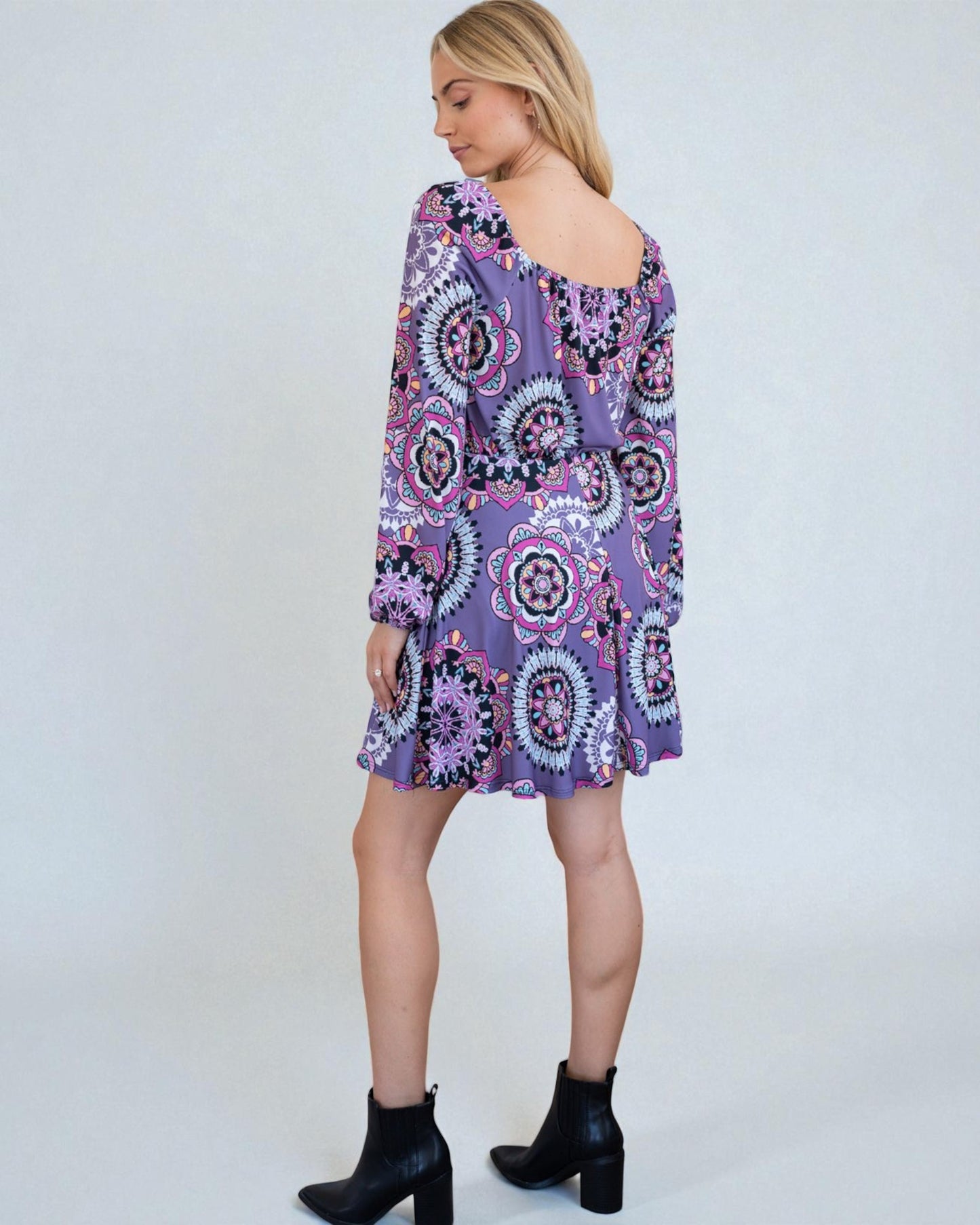 Woman wearing a purple patterned dress on a white background