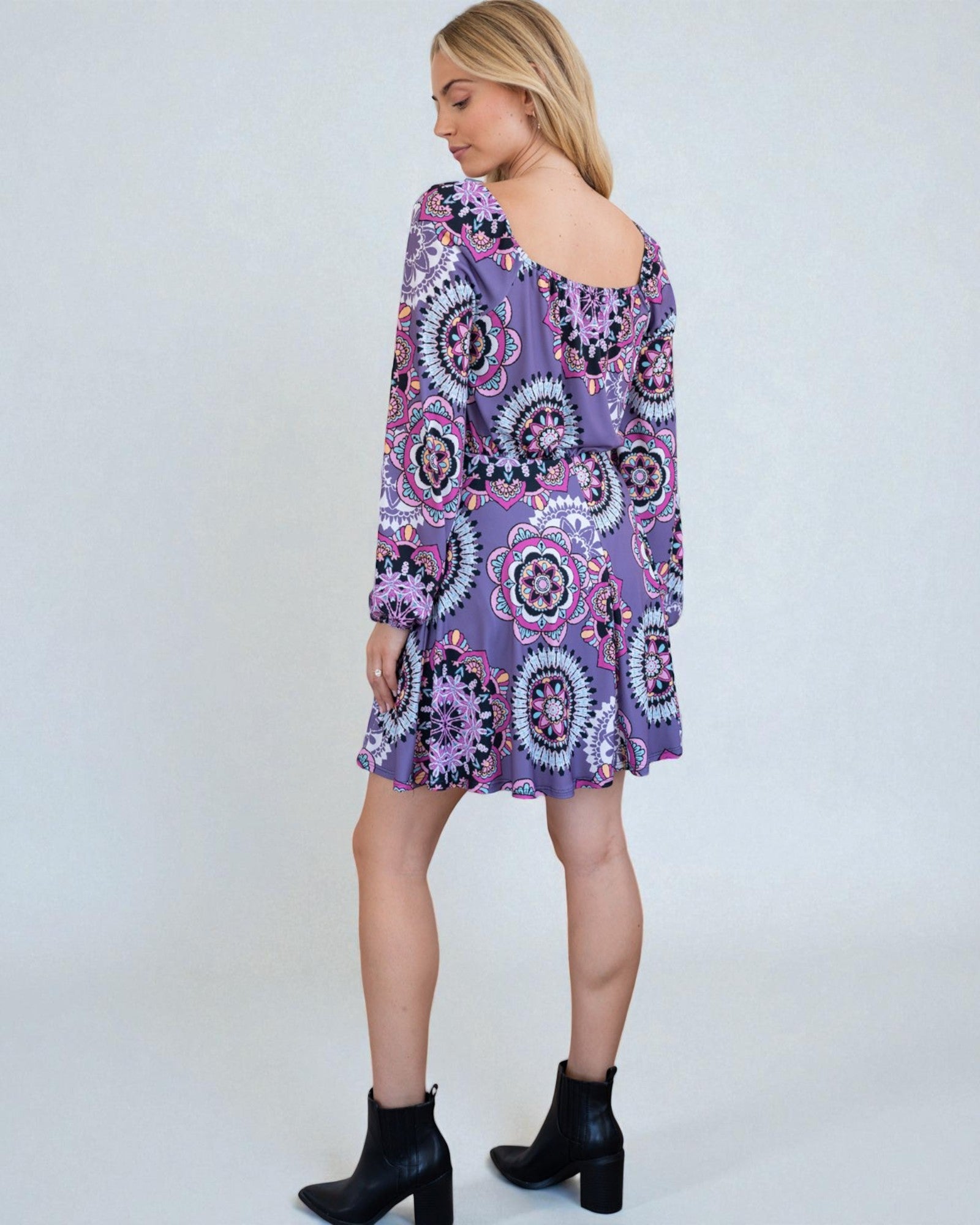Woman wearing a purple patterned dress on a white background